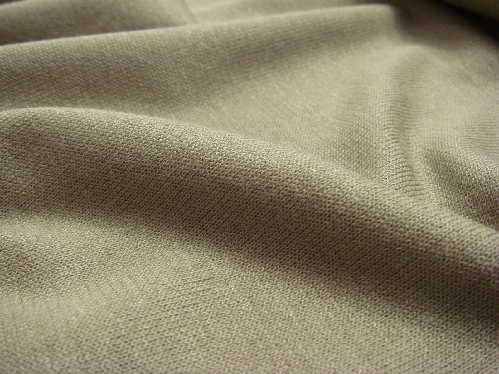 Tejido interlock jersey en primer plano, mostrando la textura y las mallas características del punto jersey.